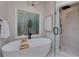 Bright bathroom featuring a soaking tub, patterned glass window, glass shower, and marble floors at 360 Hannaford Dr, Roswell, GA 30075