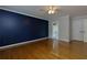 Bedroom featuring dark blue accent wall, hardwood floors, ensuite bathroom, and double door closet at 360 Hannaford Dr, Roswell, GA 30075