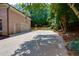Long driveway leading to a brick home with an attached garage, surrounded by mature trees at 360 Hannaford Dr, Roswell, GA 30075