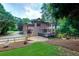 Back exterior of a brick home with a spacious backyard, a deck, and a playset at 360 Hannaford Dr, Roswell, GA 30075