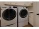 Laundry room featuring front load washer and dryer and white cabinets at 360 Hannaford Dr, Roswell, GA 30075