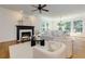 Bright living room with a fireplace, hardwood floors, and white furniture at 360 Hannaford Dr, Roswell, GA 30075
