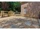 Flagstone patio next to a brick home with a gated fence in the background at 360 Hannaford Dr, Roswell, GA 30075