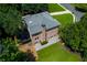 Aerial view of a brick home's rear exterior highlighting a patio, manicured lawn, and landscaped surroundings in a private setting at 360 Hannaford Dr, Roswell, GA 30075