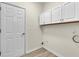 Neutral laundry room with laminate floors and white overhead cabinets at 1249 Creek Forest Ln # Bldg 8, Austell, GA 30106