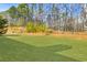 Expansive, well-maintained backyard with lush green grass and a backdrop of mature trees at 173 Northshore Xing, Dallas, GA 30157