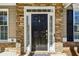 Elegant front door with stone surround, sidelights, and stylish hardware at 173 Northshore Xing, Dallas, GA 30157