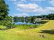 Scenic pond reflecting blue sky, surrounded by mature trees and green landscape. Perfect for relaxation at 173 Northshore Xing, Dallas, GA 30157