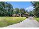 Charming brick home featuring a well-manicured lawn and long driveway on a sunny day at 2247 Cypress Ave, Morrow, GA 30260