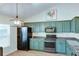 Well-lit kitchen featuring modern appliances, stylish cabinets, and wood floors at 2423 Walnut Tree Ln, Buford, GA 30519