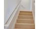 Carpeted stairs with white rails lead to the next level, ensuring safe passage and style at 2423 Walnut Tree Ln, Buford, GA 30519