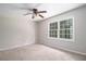 Bright bedroom with a large window, ceiling fan, and neutral carpeting provides a cozy feel at 60 Newton Ridge Dr, Covington, GA 30014