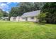 Exterior view of a cozy home with neutral siding, a well-manicured lawn, and a detached garage at 60 Newton Ridge Dr, Covington, GA 30014