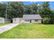 Exterior view of a cozy home with neutral siding, a well-manicured lawn, and a detached garage at 60 Newton Ridge Dr, Covington, GA 30014