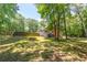 Sprawling backyard with mature trees and view of house at 10560 Haynes Bridge Rd, Alpharetta, GA 30022