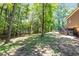 Large backyard with mature trees, a wooden deck, and plenty of space for outdoor activities at 10560 Haynes Bridge Rd, Alpharetta, GA 30022
