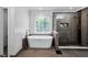 Bathroom with a sleek freestanding tub, walk-in shower with tile surround, and bright natural light at 10560 Haynes Bridge Rd, Alpharetta, GA 30022