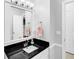 Clean and bright bathroom featuring a black granite countertop and vanity at 10560 Haynes Bridge Rd, Alpharetta, GA 30022