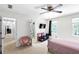 Well-lit bedroom featuring a ceiling fan, two windows, and pink chair at 10560 Haynes Bridge Rd, Alpharetta, GA 30022