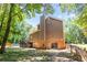 Exterior showcasing a two-story home with brick and siding, a spacious backyard, and mature trees at 10560 Haynes Bridge Rd, Alpharetta, GA 30022