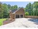 Two-story home with attached two-car garage and extended driveway surrounded by mature trees at 10560 Haynes Bridge Rd, Alpharetta, GA 30022