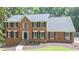 Charming brick home with black shutters, green landscaping, and a well-manicured lawn at 10560 Haynes Bridge Rd, Alpharetta, GA 30022