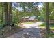 Two-story home with brick and vinyl siding and a long driveway in a wooded lot at 10560 Haynes Bridge Rd, Alpharetta, GA 30022
