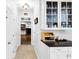 Hallway featuring storage cabinets and glimpse of brick fireplace in living room at 10560 Haynes Bridge Rd, Alpharetta, GA 30022