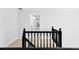 Upstairs hallway with black handrail and neutral carpet; white walls at 10560 Haynes Bridge Rd, Alpharetta, GA 30022