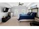 Spacious primary bedroom with tray ceilings, two windows, dresser, and modern decor at 10560 Haynes Bridge Rd, Alpharetta, GA 30022