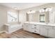 Bathroom with double vanity, soaking tub, wood floors and large mirrors at 424 Citronelle Dr, Woodstock, GA 30188