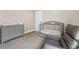 Comfortable Bedroom with gray crib, dresser, and cushioned chair on soft carpeting at 424 Citronelle Dr, Woodstock, GA 30188