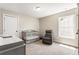 Bedroom with crib, rocker, carpet, and large window with natural light at 424 Citronelle Dr, Woodstock, GA 30188