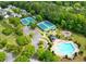 Aerial view of community pool with lounge chairs, playground, pool house, and tennis courts nearby at 424 Citronelle Dr, Woodstock, GA 30188