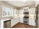 Contemporary kitchen with white cabinetry, stainless appliances, and modern lighting at 424 Citronelle Dr, Woodstock, GA 30188
