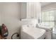 Functional laundry room with washer, dryer, overhead cabinets, and a window at 424 Citronelle Dr, Woodstock, GA 30188