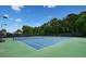 Well-maintained tennis courts with a green and blue surface and black fencing for privacy at 424 Citronelle Dr, Woodstock, GA 30188