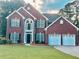 Lovely brick home with a manicured lawn, black shutters, and an attached two-car garage at 10770 Glenhurst Pass, Duluth, GA 30097