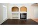 Living room with a fireplace, white shelving, and dark wood floors at 10770 Glenhurst Pass, Duluth, GA 30097