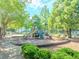Community playground nestled amongst mature trees, featuring slides and benches at 10770 Glenhurst Pass, Duluth, GA 30097