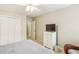 Neutral bedroom with a closet, wicker chair, dresser, and a bed with patterned gray cover at 1386 Sheffield Glen Ne Way, Atlanta, GA 30329