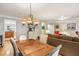 Dining area with a wood table, stylish chandelier, and open access to living room at 1386 Sheffield Glen Ne Way, Atlanta, GA 30329