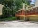 Exterior view of a home featuring attached garages and a screened-in porch, surrounded by lush trees at 1386 Sheffield Glen Ne Way, Atlanta, GA 30329