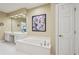 Bright bathroom features a soaking tub, double vanity, and a large mirror at 25 Hampreston Court Ct, Johns Creek, GA 30022