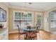 Bright breakfast nook features hardwood floors, a glass table with seating for four, and natural light from the large window at 25 Hampreston Court Ct, Johns Creek, GA 30022