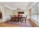 Formal dining room boasts an elegant chandelier, wainscoting, hardwood floors covered by an eye-catching area rug, and six chairs at 25 Hampreston Court Ct, Johns Creek, GA 30022
