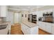Well-lit kitchen featuring stainless steel appliances, white cabinets, hardwood floors and an island with a light countertop at 25 Hampreston Court Ct, Johns Creek, GA 30022