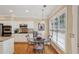 Eat-in kitchen with a glass table and seating adjacent to stainless steel appliances and white cabinets at 25 Hampreston Court Ct, Johns Creek, GA 30022