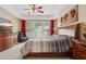 Primary bedroom with tray ceilings, ceiling fan, large windows with red curtains and furniture set at 25 Hampreston Court Ct, Johns Creek, GA 30022