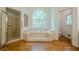 Luxurious bathroom features arched window above soaking tub and walk-in shower with glass door at 2814 Tanner Lake Nw Trl, Marietta, GA 30064